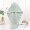 A light mint green microfiber towel wrap for hair is displayed on a white surface.