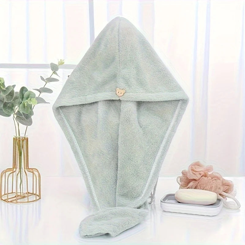 A light mint green microfiber towel wrap for hair is displayed on a white surface.