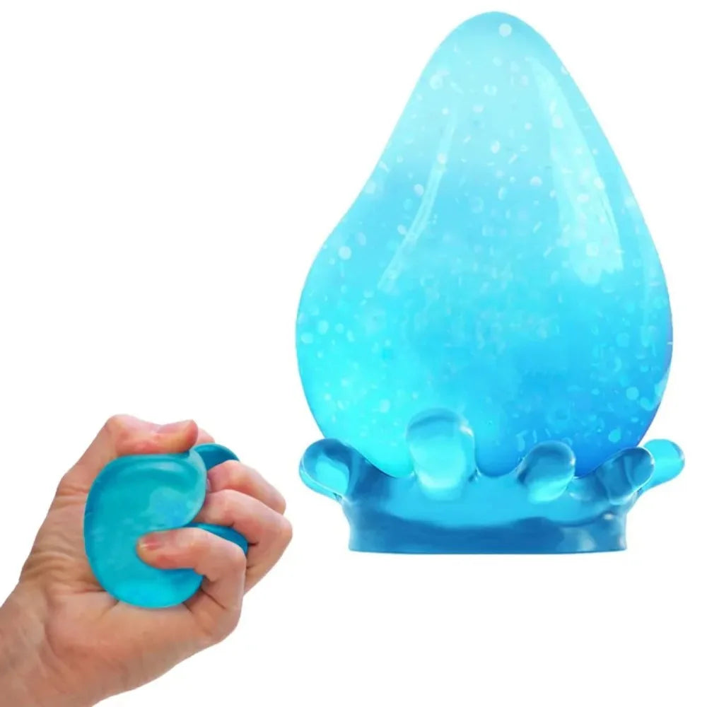 Eine Hand hält einen durchsichtigen blauen Stressball in Tropfenform, gefüllt mit kleinen Bläschen.
