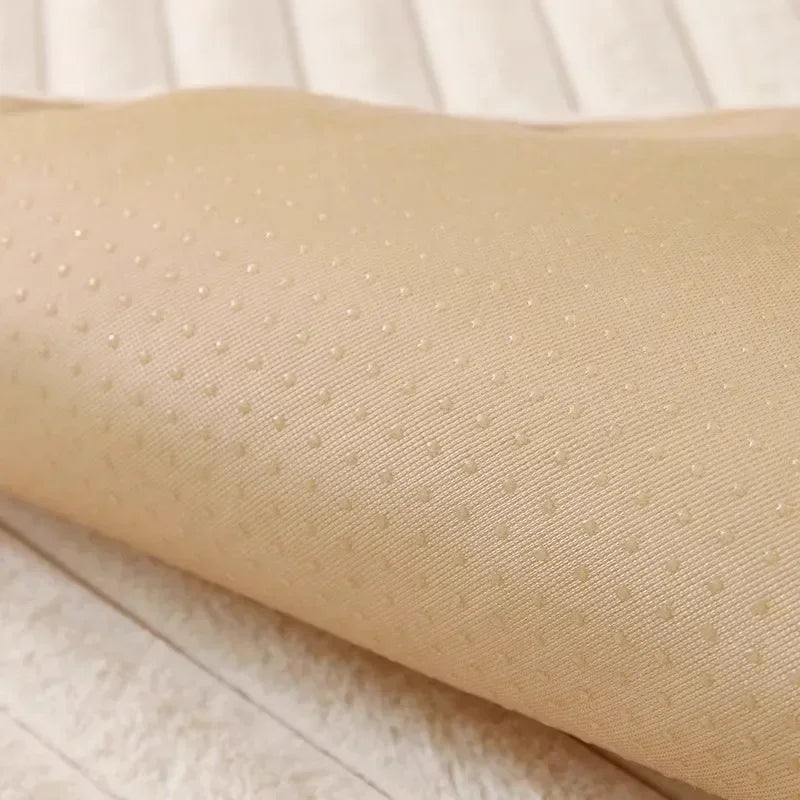 A beige cozy plush anti-slip sofa cushion mat rolled up on a light wooden surface.