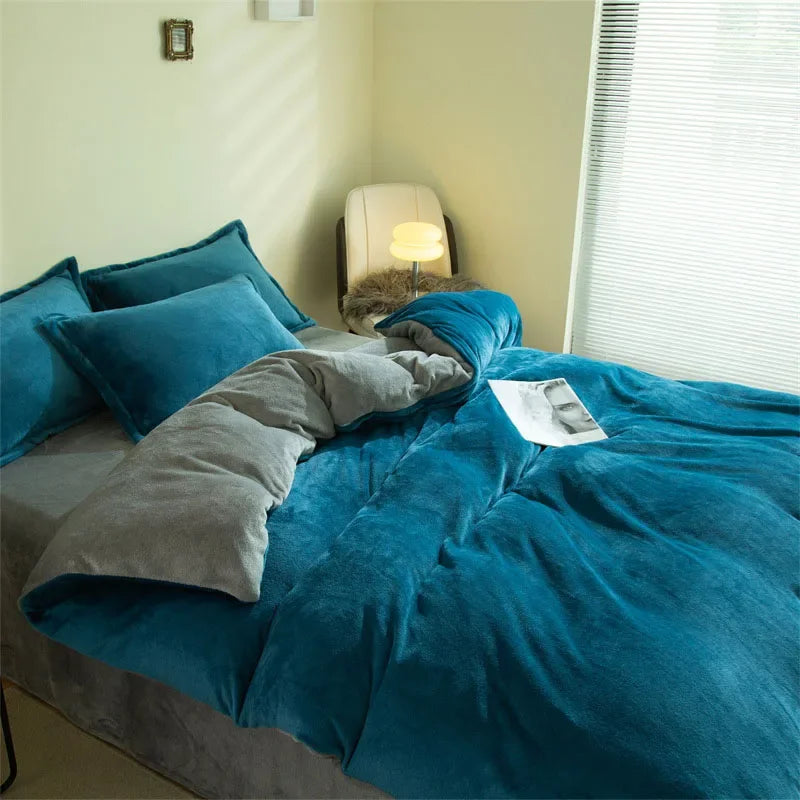 A teal flannel duvet cover is spread on a bed with gray accents and a lamp in the background.