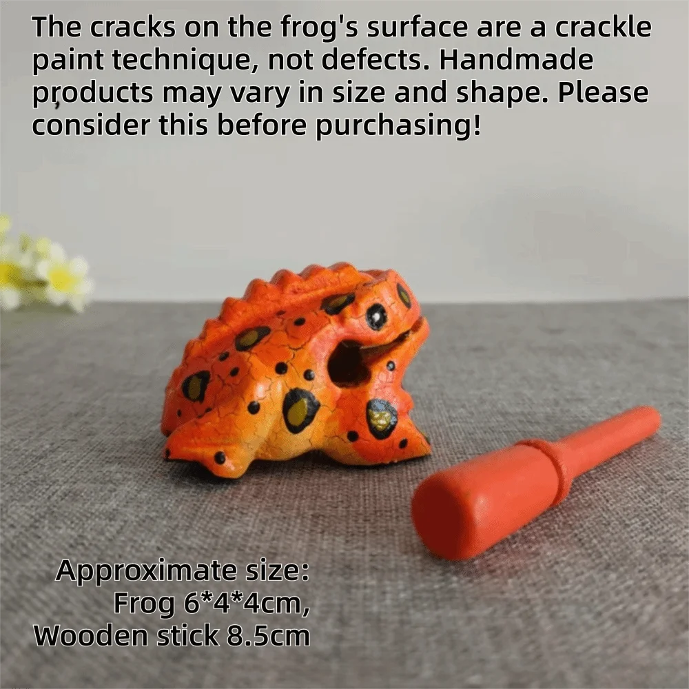 An orange handcrafted wooden frog percussion instrument with a stick, displayed on a gray surface.