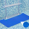 A silver ladder mat with a textured surface is placed on a blue mat in front of a tiled wall.