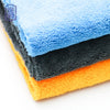 Stack of three microfiber cleaning cloths in blue, gray, and orange colors.