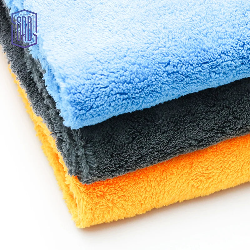 Stack of three microfiber cleaning cloths in blue, gray, and orange colors.