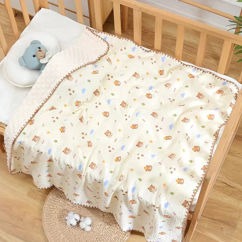 A cream-colored cotton gauze baby swaddle blanket with an adorable bear print, displayed in a wooden crib.