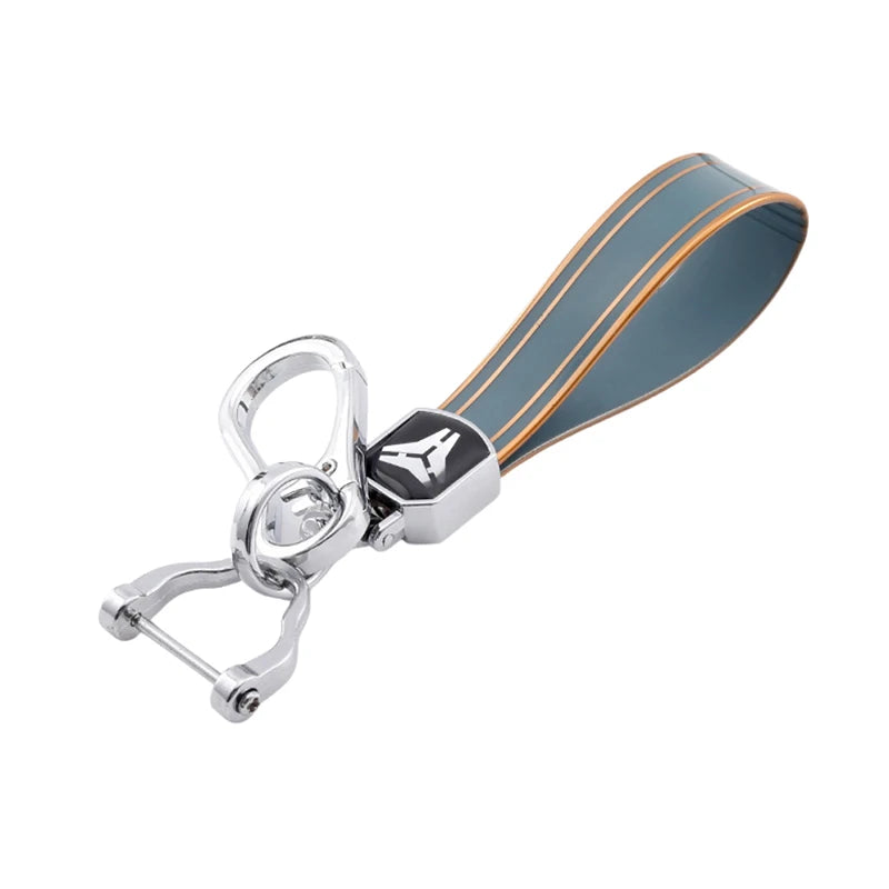 Silver car key case cover with a dark blue and orange striped leather grip.