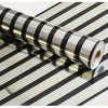 Roll of luxury mirror embossed wall panels in black and silver stripes lying on a striped surface