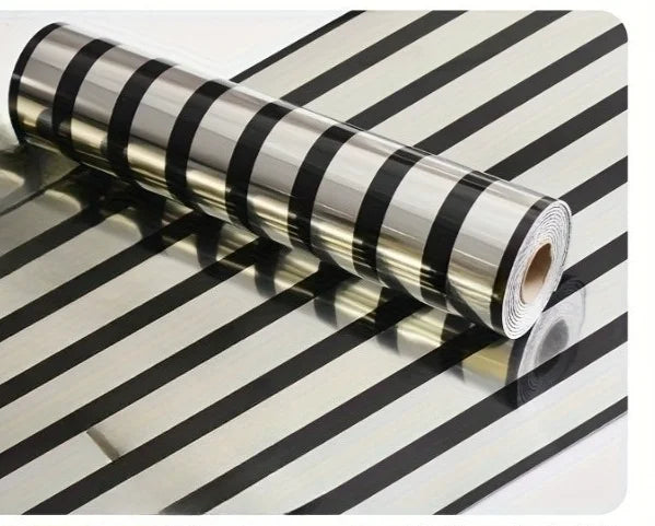 Roll of luxury mirror embossed wall panels in black and silver stripes lying on a striped surface