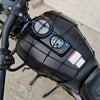 A black motorcycle cargo net with scratch-free hooks is mounted on a bike frame.