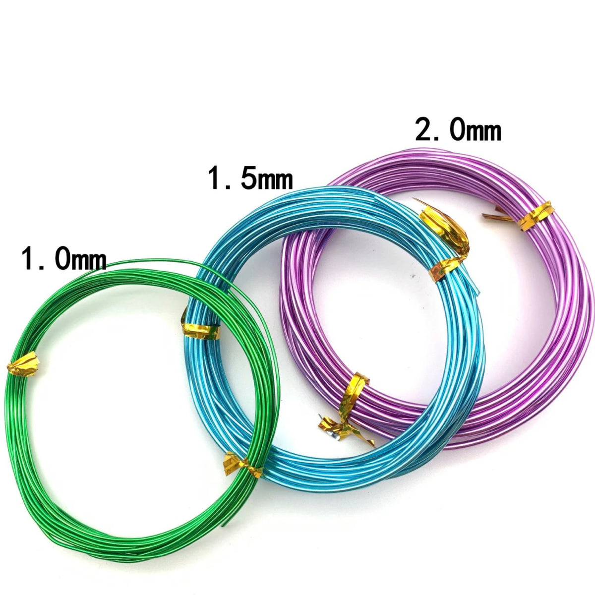 Three coils of anodized aluminum jewelry wire in green, blue, and purple with various diameters labeled.