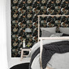 A bedroom featuring a headboard with a dark floral wallpaper and light gray bedding.