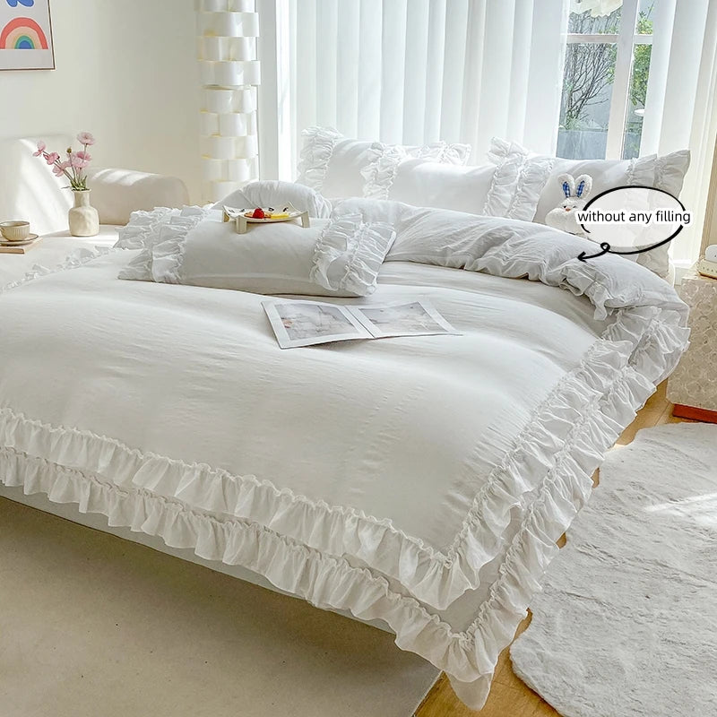 White ruffled duvet cover set with pillows on a bed in a bright room.