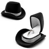 Black felt cowboy hat with silver trim and an open velvet jewelry storage box displaying a ring.