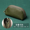Olive green PU leather key organizer wallet with a zipper shown on a dark green background.