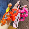 A hand holds a colorful fitness keychain featuring orange, pink, and yellow beads and charms.