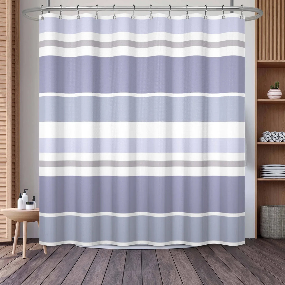 A shower curtain featuring a vertical geometric stripe pattern in shades of light purple, gray, and white.