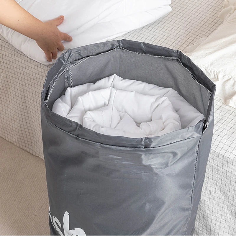 A gray drawstring laundry bag filled with white clothes, shown in a close-up view.
