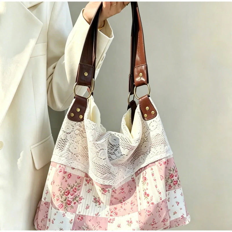 Un gros plan d'un sac à épaule patchwork floral bohème en tissu de dentelle blanche et sangles en cuir marron.