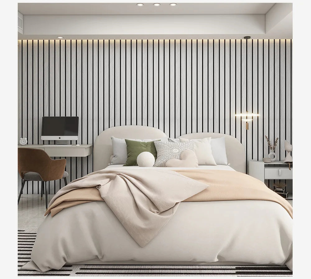 A bedroom featuring a bed with beige linens against a wall covered in vertical light gray wood grain wallpaper.