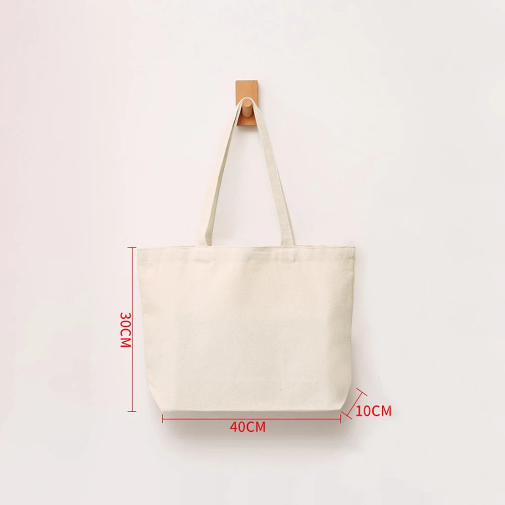A beige canvas shopping tote bag with a wooden handle, shown flat against a white background.