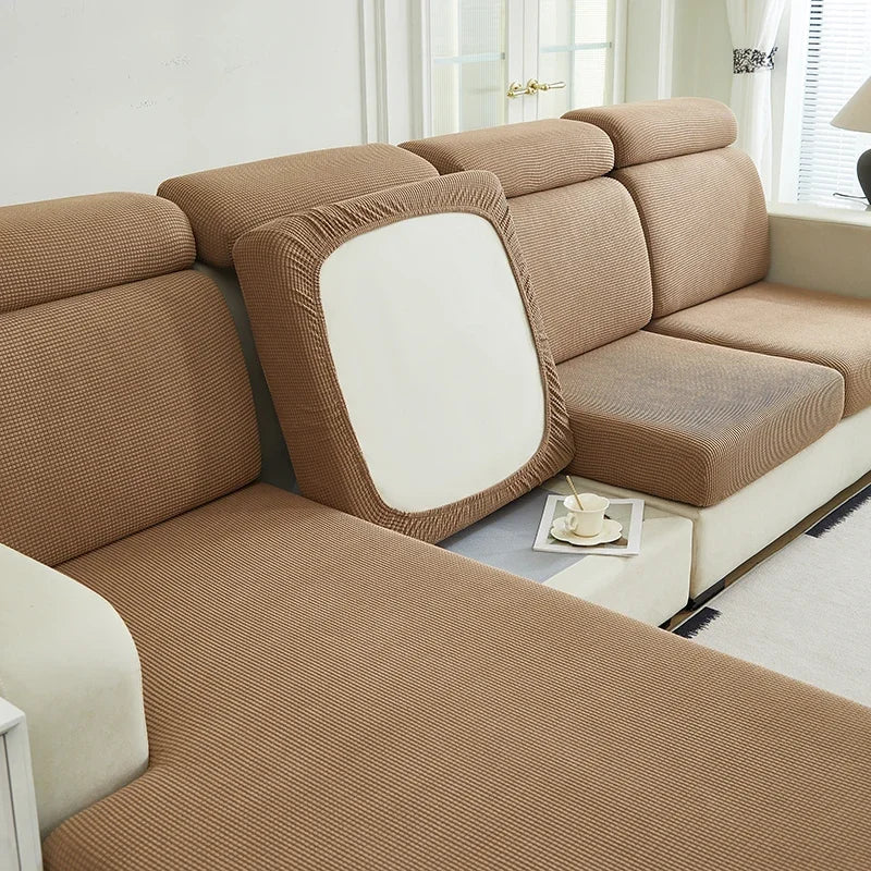A beige Jacquard stretch sofa slipcover with a white accent panel shown in a bright room.