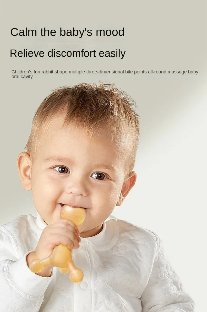A baby is shown using a yellow silicone rabbit shape teether for oral massage.