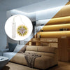 A modern living room interior featuring a sofa and wooden cabinetry with an illuminated motion-activated LED strip light disp