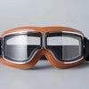 A pair of retro foldable motorcycle goggles in brown leather with silver frames and black lenses.