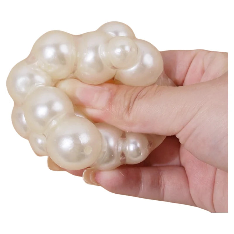 Eine Hand hält einen Haufen weißer Perlen, die als Knetball für Stressabbau dienen.