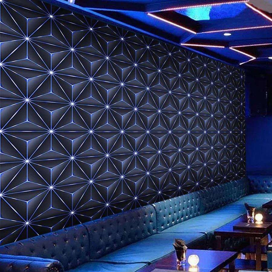 A dark blue geometric patterned wallpaper covers a wall in a modern interior with blue accent lighting.