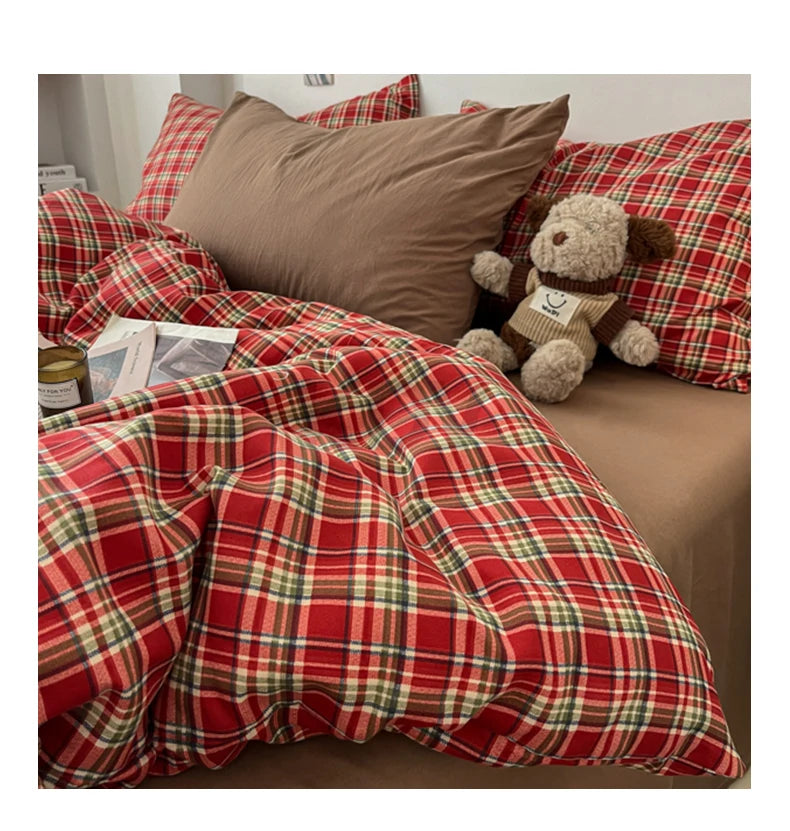 A vintage red plaid duvet cover set featuring a checkered pattern and a teddy bear pillow on a bed.