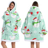 Eine Frau modelliert einen hellgrünen, patchworkartigen, oversized Fleece-Hoodie mit weißen und roten Schneeflocken-Designs.