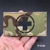 A tactical patch featuring a white cross inside a black circle on a camouflage fabric with hook-and-loop backing.