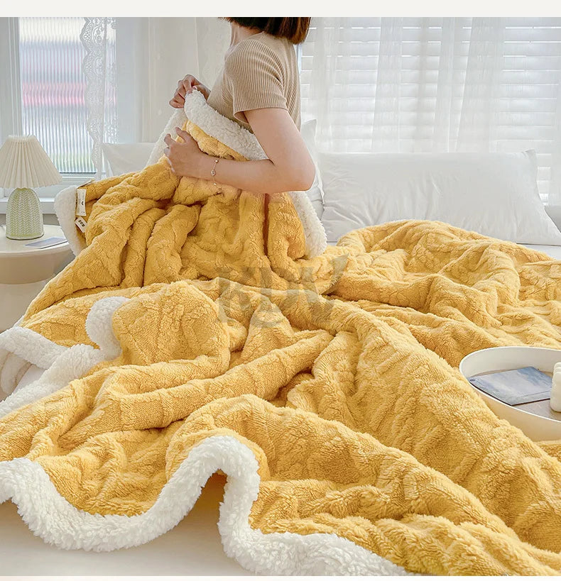 A fluffy yellow fleece throw blanket draped over a bed, showing its thick texture and white trim.