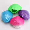 A collection of three colorful mermaid shell squeeze toys in green, blue, and purple.