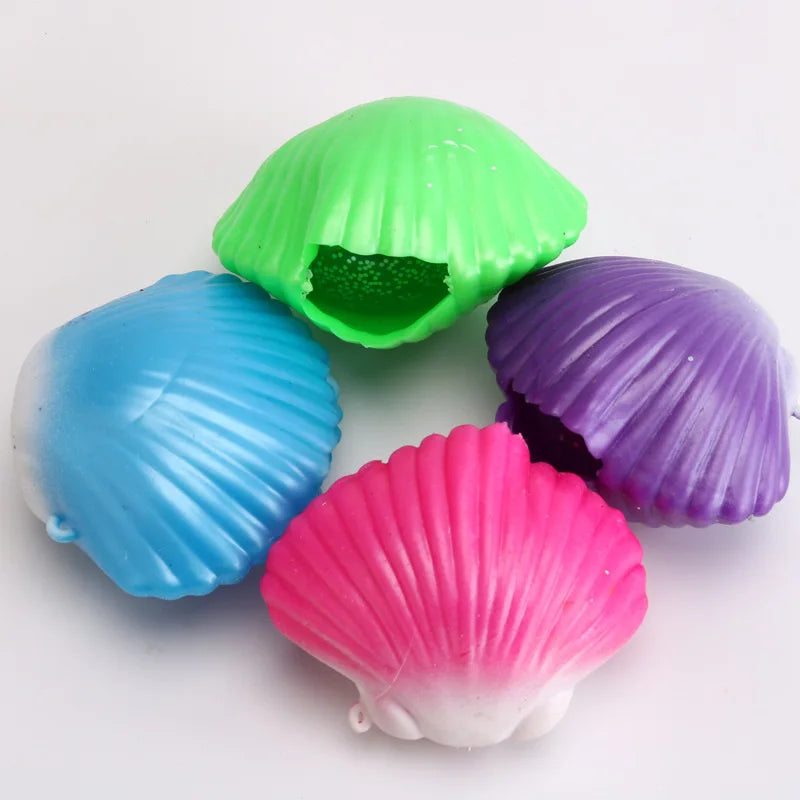 A collection of three colorful mermaid shell squeeze toys in green, blue, and purple.