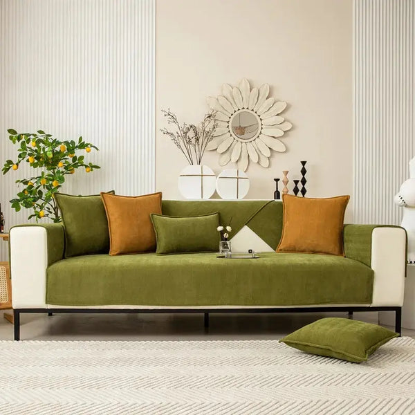 A modern sofa covered in olive green chenille textured non-slip fabric with mustard yellow accent pillows.