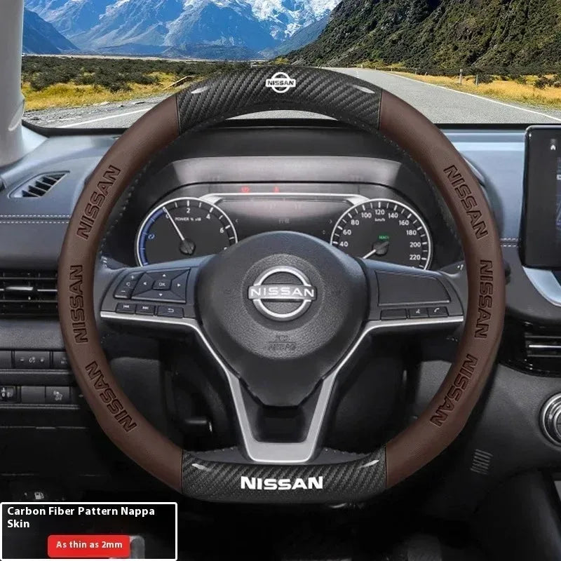 A close-up view of a Nissan steering wheel with a brown carbon fiber patterned grip and controls.
