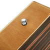 A close-up of a compact travel cajon drum with an adjustable strap, featuring a wooden body and a metal mounting piece.