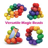 A collection of colorful magic beads in various shades of green, yellow, red, and purple.
