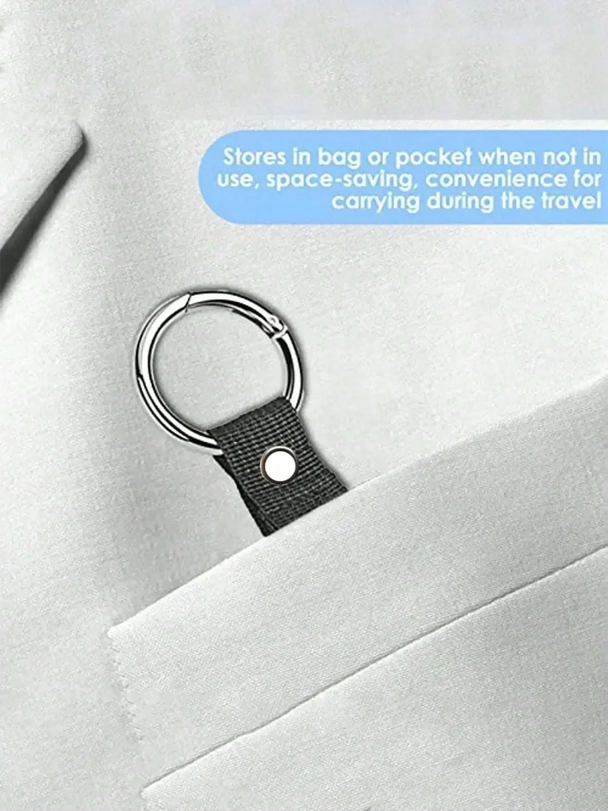 A black durable polyester luggage strap with a silver ring and ID tag is clipped onto a light gray suit jacket pocket.