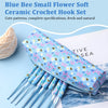 A blue ceramic crochet hook set featuring a cute blue bee pattern, displayed next to a ball of light-colored yarn.
