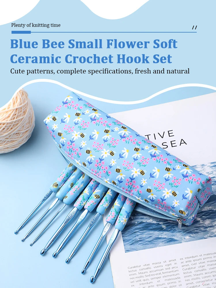 A blue ceramic crochet hook set featuring a cute blue bee pattern, displayed next to a ball of light-colored yarn.