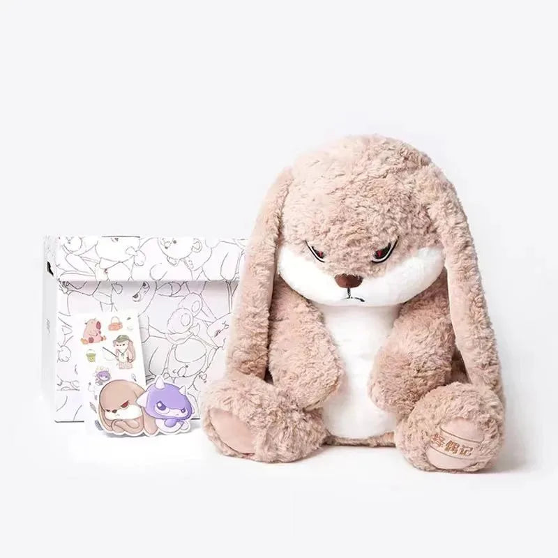 A fluffy, light brown rabbit plush toy with angry facial features is shown next to its packaging.