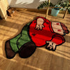 A playful cartoon carpet featuring a red body with green pants and dark boots, lying on a wooden floor.