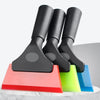 Three black car window squeegees with soft rubber blades resting on a white surface.