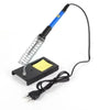 A soldering iron kit with a coiled tip, multimeter, and power cord lying on a white background.