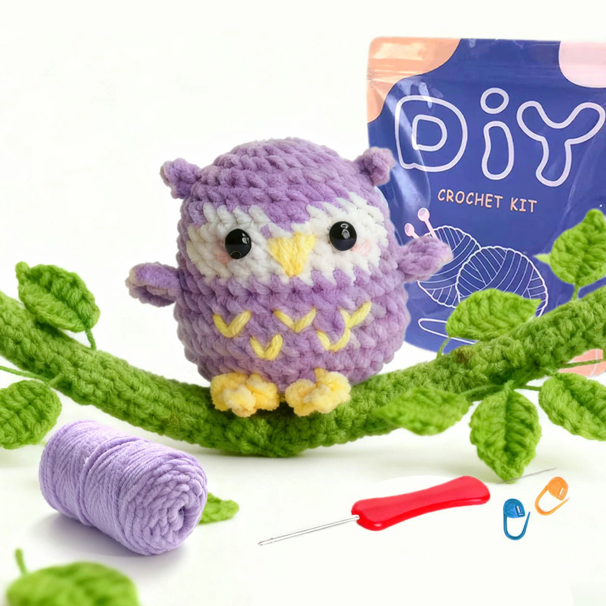 A purple crocheted owl is shown next to a blue DIY crochet kit bag and green plant elements.
