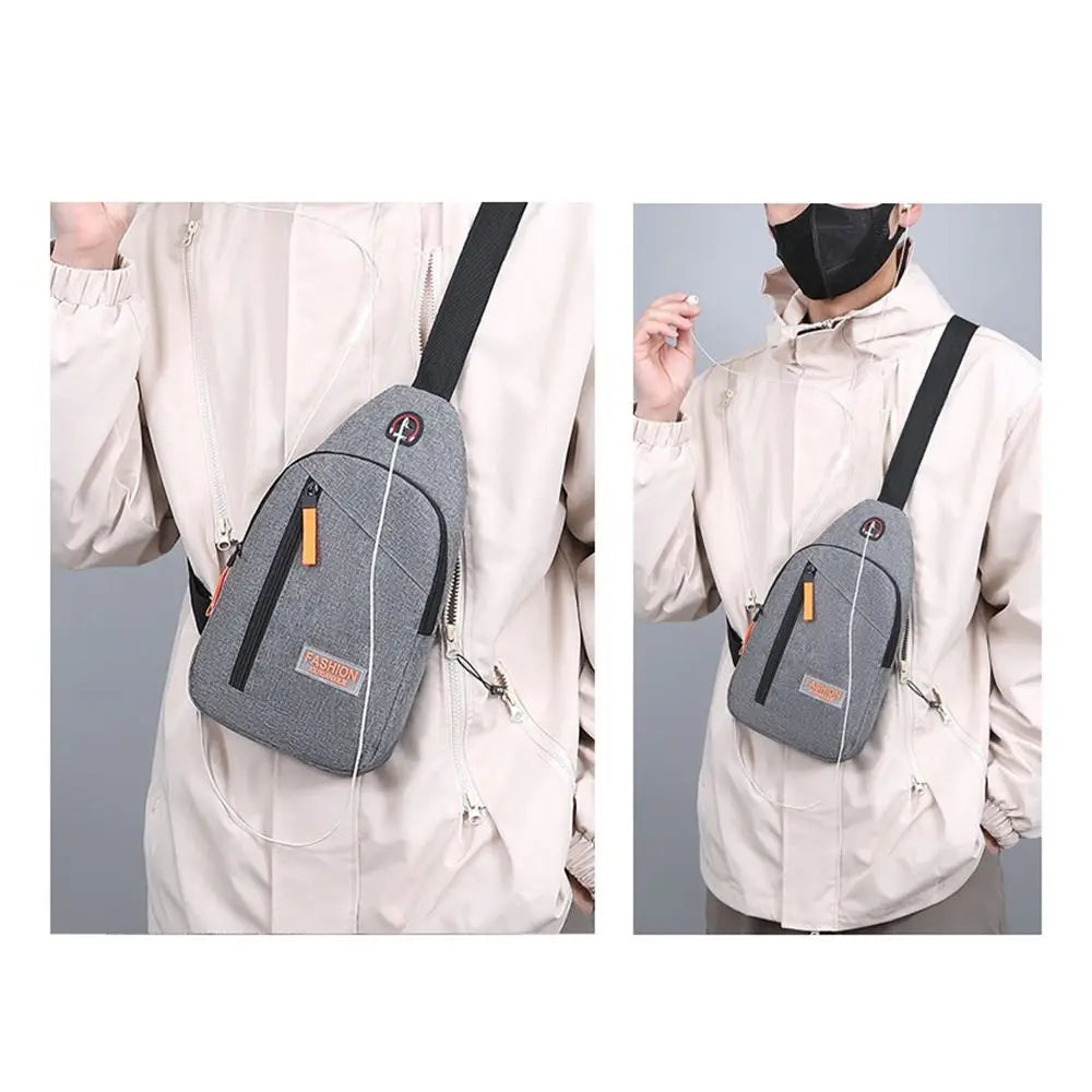A light beige canvas crossbody chest bag with black straps shown on a person's torso.